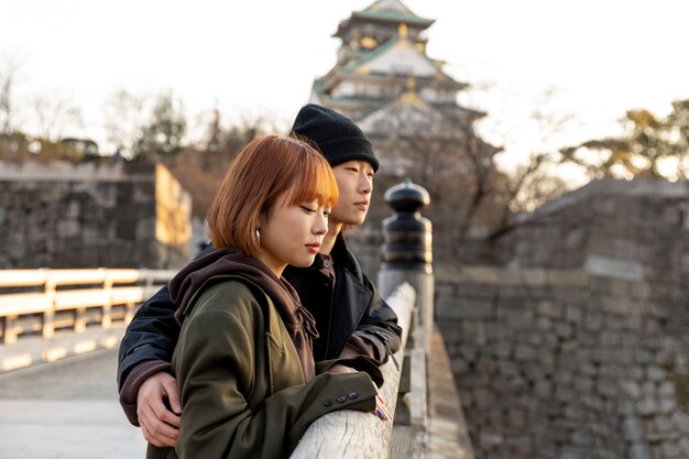 Pareja japonesa disfrutando de una cita al aire libre en un puente