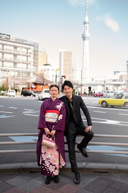 Pareja japonesa posando al aire libre y celebrando el día de la mayoría de edad