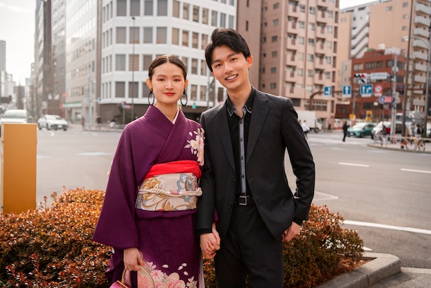 Pareja japonesa posando al aire libre y celebrando el día de la mayoría de edad