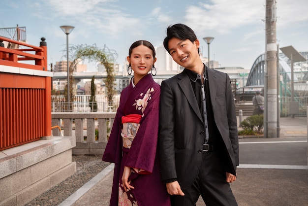 Pareja japonesa posando al aire libre y celebrando el día de la mayoría de edad