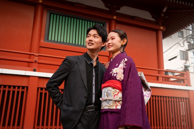 Pareja japonesa posando al aire libre y celebrando el día de la mayoría de edad