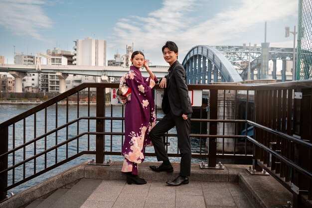Pareja japonesa posando en el puente y celebrando el día de la mayoría de edad
