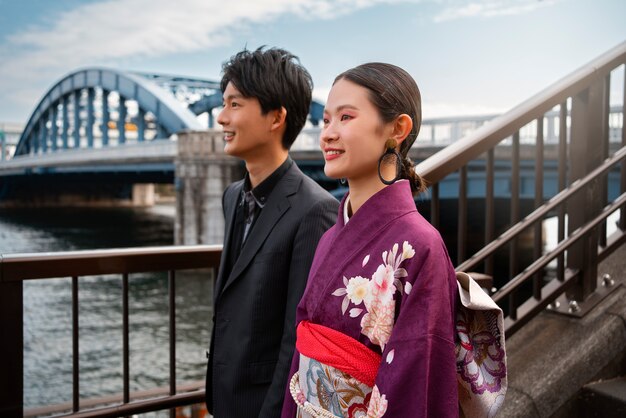 Pareja japonesa posando en el puente y celebrando el día de la mayoría de edad