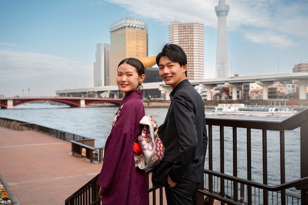 Foto gratuita pareja japonesa posando en el puente y celebrando el día de la mayoría de edad