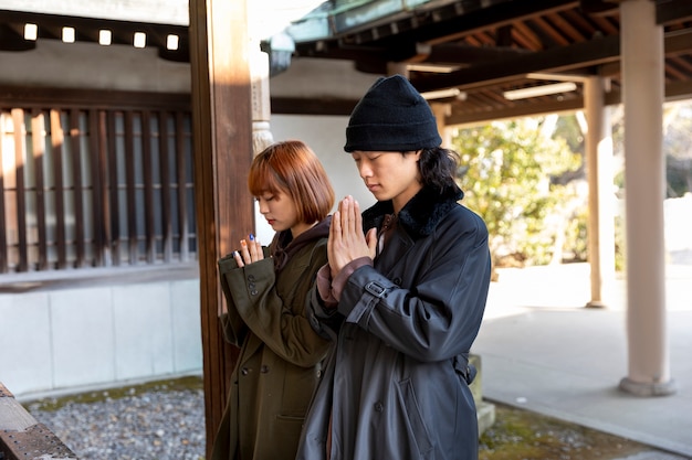 Pareja japonesa rezando en el templo durante una cita