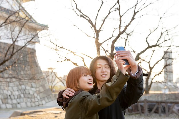 Pareja japonesa tomando un selfie al aire libre en el día blanco