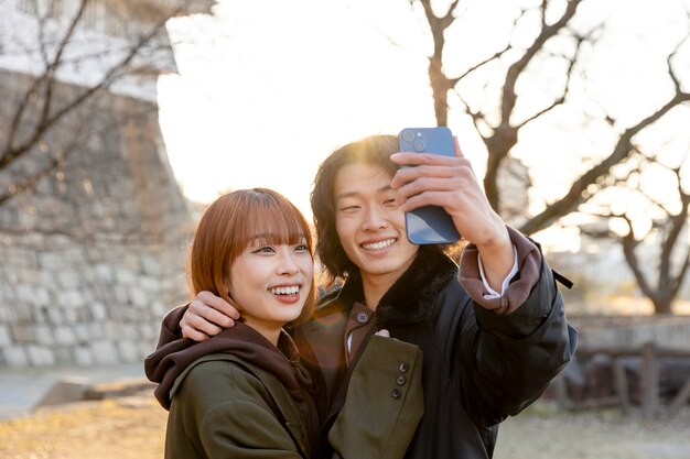 Pareja japonesa tomando un selfie al aire libre en el día blanco