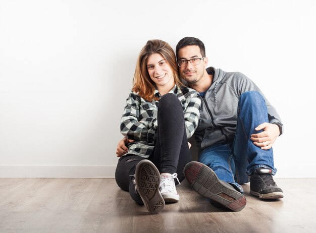 Pareja joven abrazados en el suelo