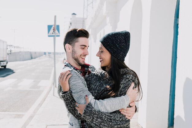 Pareja joven abrazándose al lado de calle