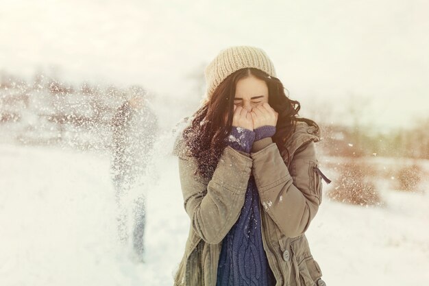 Pareja joven alegre jugando bolas de nieve