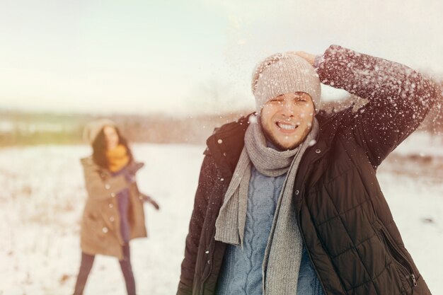 Pareja joven alegre jugando bolas de nieve