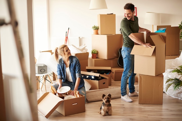 Pareja joven en apartamento nuevo con perro pequeño