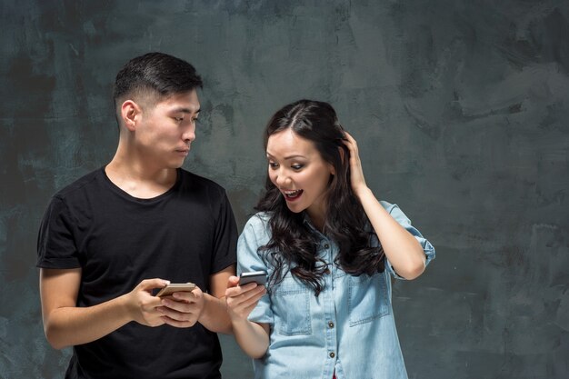 Pareja joven asiática con teléfono móvil, retrato de portarretrato.