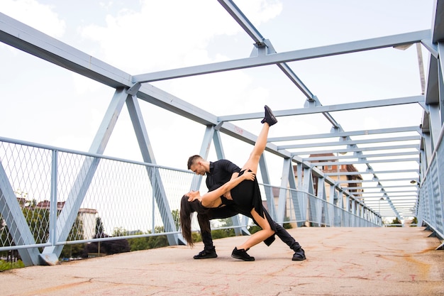 Pareja joven atractiva tangoing en el puente