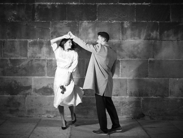 Pareja joven bailando en la calle por la noche