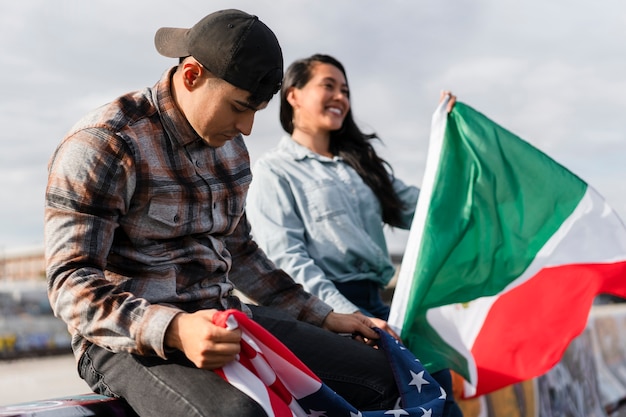 Pareja joven con banderas junto al río