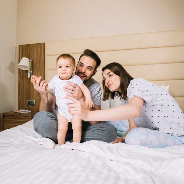 Foto gratuita pareja joven con bebé por la mañana