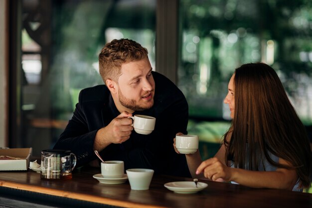 Pareja joven bebiendo té en café