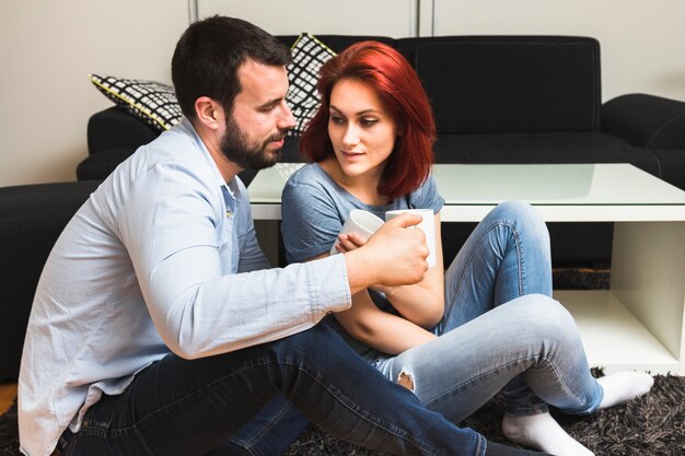 Pareja joven bebiendo té en casa