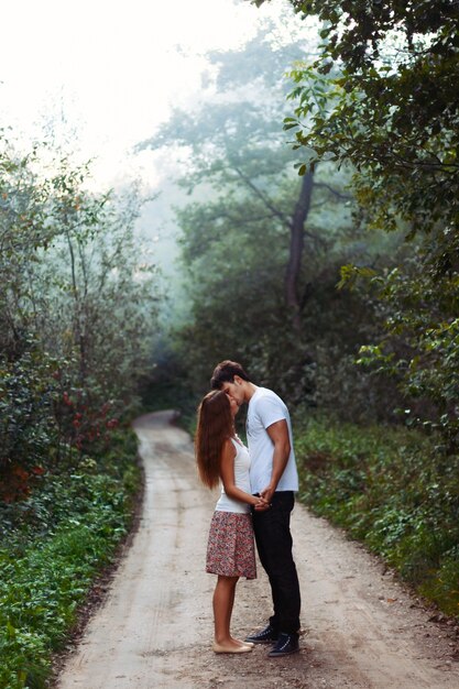 Pareja joven besándose en un día con niebla