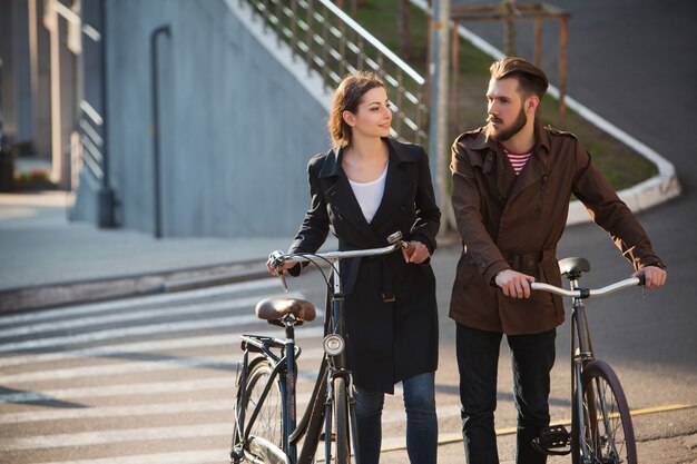 Pareja joven en bicicleta frente a la ciudad