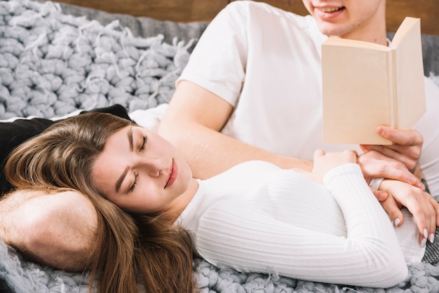 Pareja joven en blanco descansando en el sofá