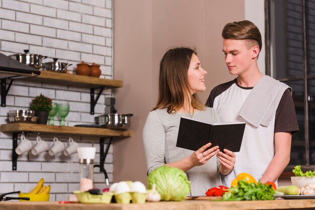 Pareja joven con bloc de notas en la cocina