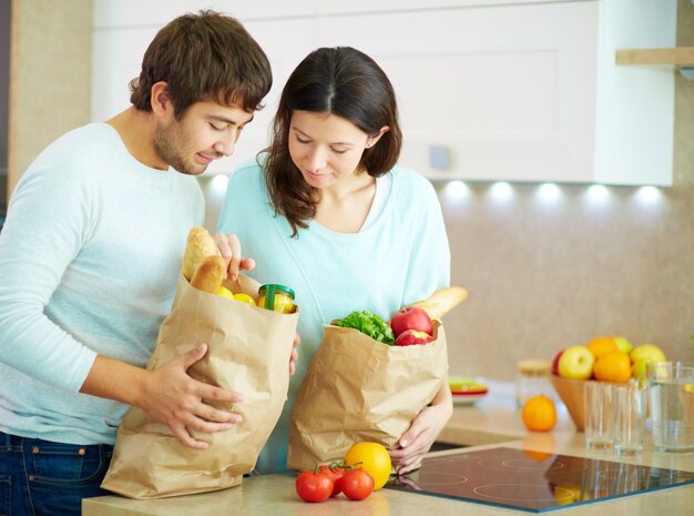 Pareja joven con bolsas de la compra en casa