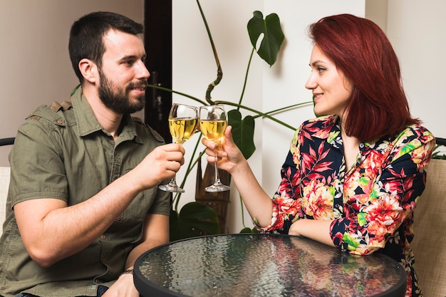 Foto gratuita pareja joven brindando copas en casa