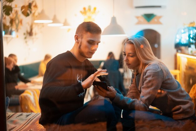 Pareja joven en café con interior elegante