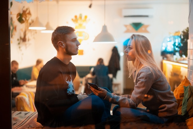 Pareja joven en café con interior elegante