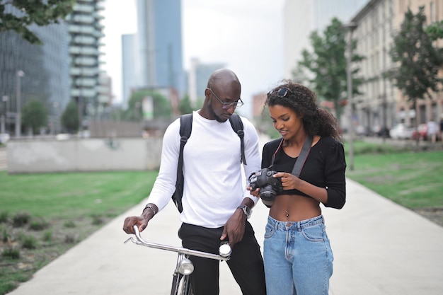 Una pareja joven en la calle mira la pantalla de una cámara