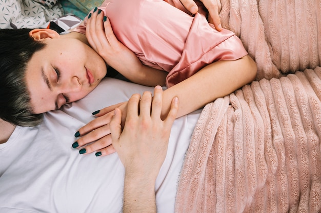 Pareja joven en la cama por la mañana