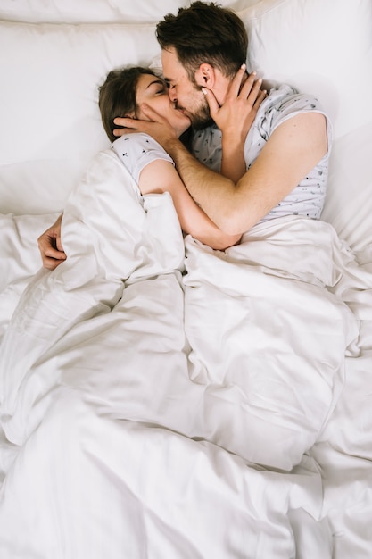 Foto gratuita pareja joven en la cama por la mañana