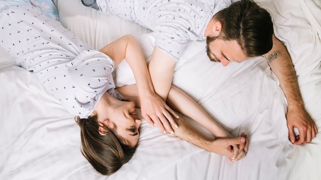 Pareja joven en la cama por la mañana