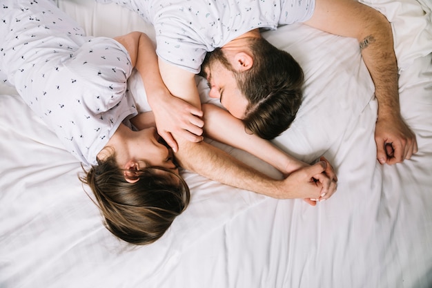 Pareja joven en la cama por la mañana