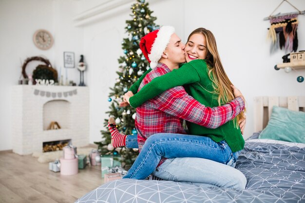 Pareja joven en la cama en navidad