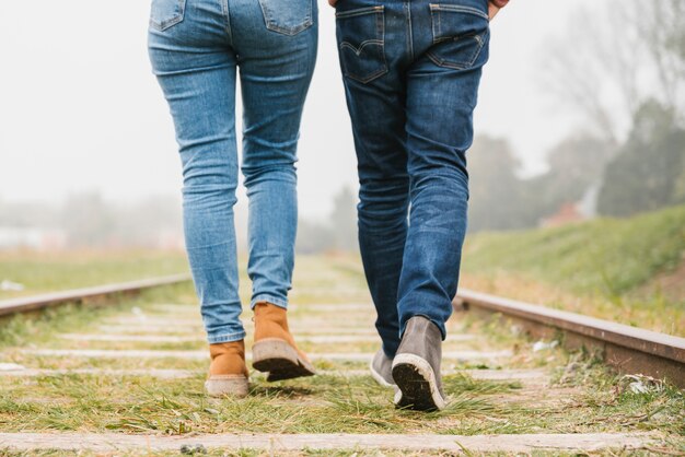 Pareja joven caminando a lo largo de las pistas juntos