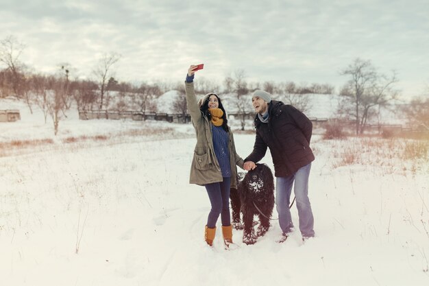 Pareja joven caminando con un perro en un día de invierno