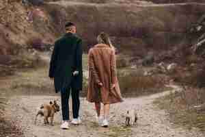 Foto gratuita pareja joven caminando sus bulldogs franceses en el parque