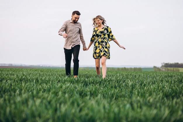 Pareja joven en el campo con hierba verde