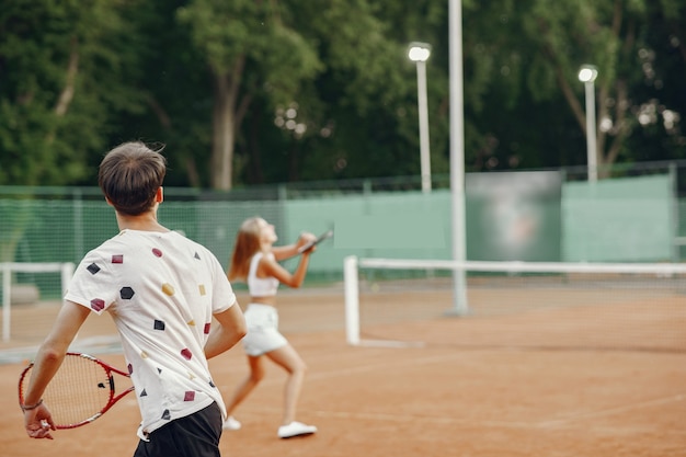 Foto gratuita pareja joven en la cancha de tenis. dos tenistas en ropa deportiva.