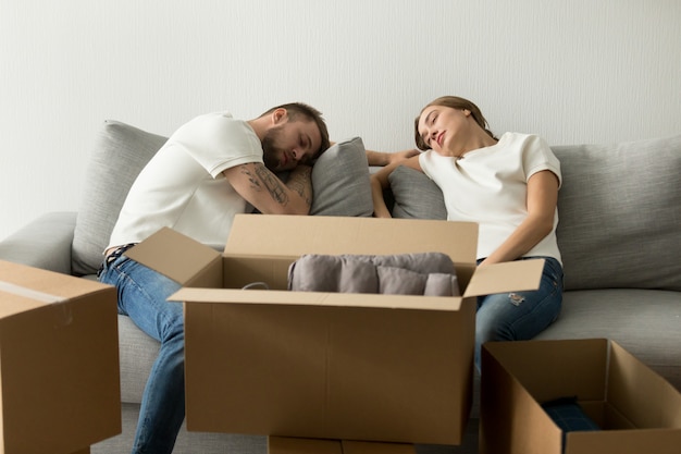 Foto gratuita pareja joven cansada que se relaja en el sofá que se muda a la nueva casa