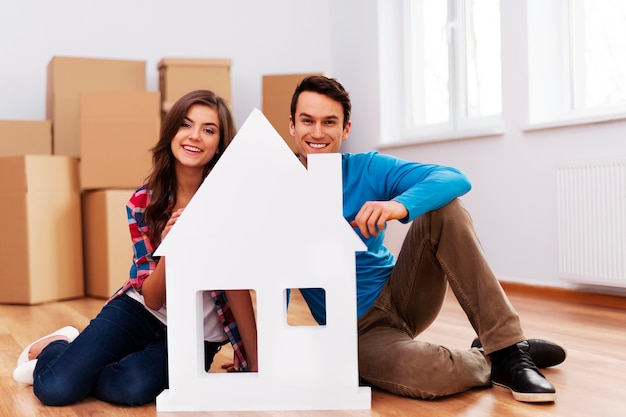 Pareja joven, con, cartel de la casa