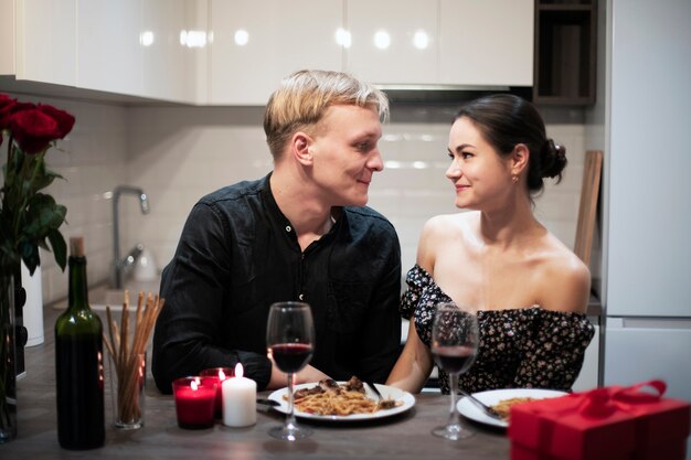 Pareja joven celebrando el día de san valentín mientras almuerza y vino juntos