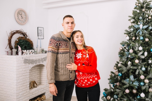 Foto gratuita pareja joven celebrando navidad en casa