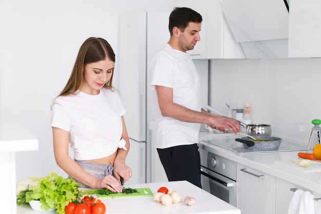 Pareja joven cocinando en casa