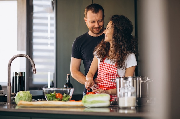 Pareja joven cocinando juntos en la cocina