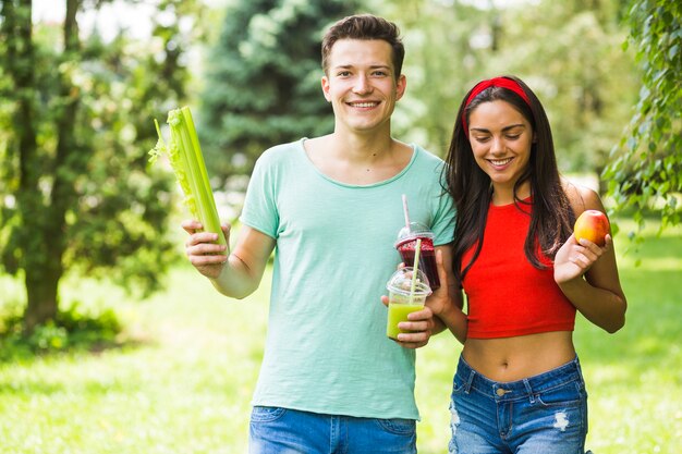 Pareja joven con comida sana en el jardín