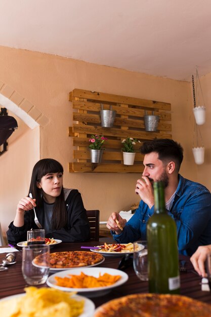 Pareja joven comiendo comida en el restaurante